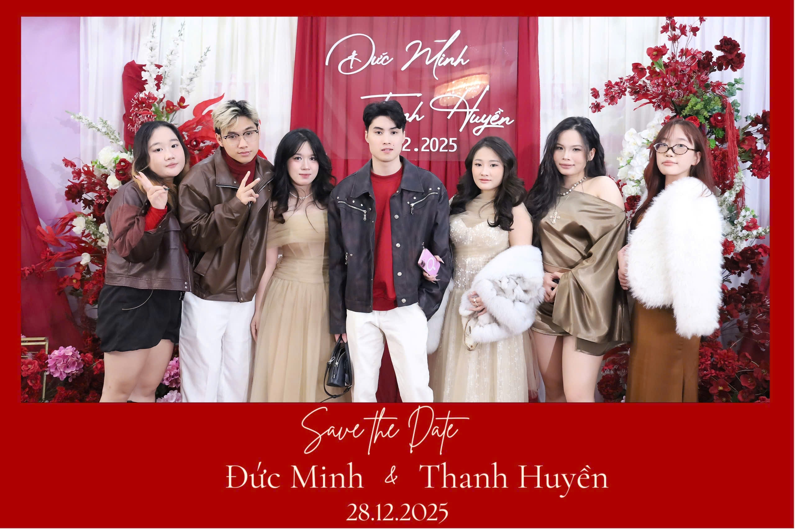 Nhóm khách mời chụp ảnh trước backdrop đỏ tại sự kiện của Chuối Photobooth